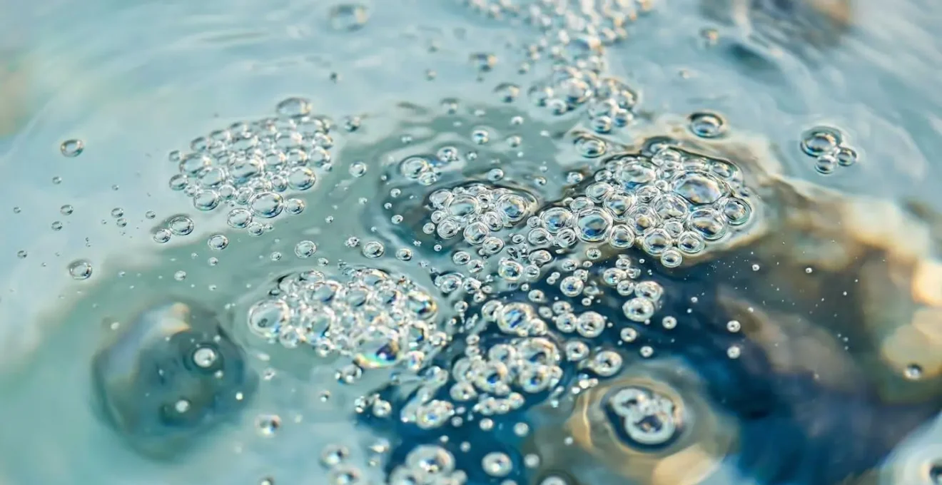 Primo piano ravvicinato di acqua termale cristallina con bolle e riflessi luminosi